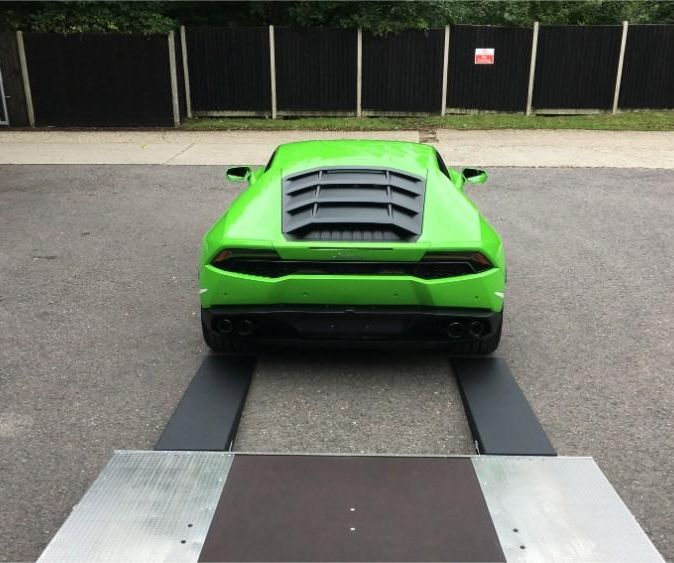 green sports car being unloaded from our truck