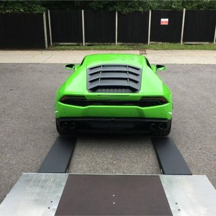 green sports car being unloaded from our truck
