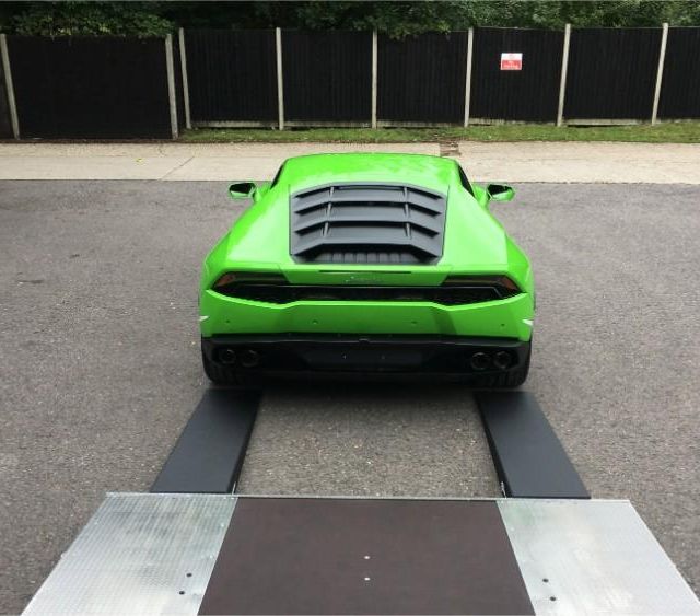 green sports car being unloaded from our truck